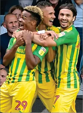  ??  ?? MATCHWINNE­R: Substitute Grady Diangana is mobbed by team-mates Kieran Gibbs and Filip Krovinovic after helping the visitors to victory at Kenilworth Road