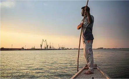  ?? ?? a fisherman standing on his boat on shatt al-arab, the confluence of the Tigris and euphrates rivers that empties into the Gulf. — afp