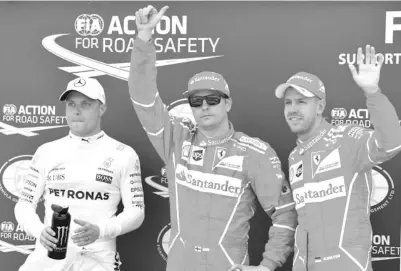  ?? — AFP photo ?? Ferrari’s Finnish driver Kimi Raikkonen (C) celebrates after winning the pole position next to second placed Ferrari’s German driver Sebastian Vettel (R) and third placed Mercedes’ Finnish driver Valtteri Bottas after the qualifying session at the Monaco street circuit, on May 27, 2017 in Monaco, a day ahead of the Monaco Formula 1 Grand Prix.