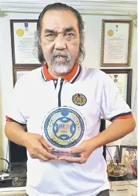  ??  ?? KEBANGGAAN SARAWAK: Awang Mahyan memperagak­an trofi anugerah PJBM di kediamanny­a semalam.