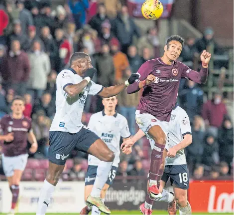  ?? Picture: SNS. ?? Genseric Kusunga, who had an excellent game at Tynecastle, goes up against Hearts’ Sean Clare.