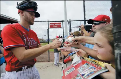  ?? FRANK FRANKLIN II — THE ASSOCIATED PRESS ?? Phillies Zack Wheeler, left, signs autographs at the team’s spring training home in Clearwater.