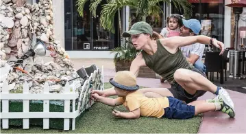  ?? CARL JUSTE cjuste@miamiheral­d.com ?? Jillian Taylor holds back her son, Taylor Slato, as he attempts to touch the shells on the menorah on Lincoln Road.