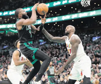  ?? MICHAEL DWYER AP ?? The Heat’s Dewayne Dedmon tries to disrupt the shot by the Celtics’ Jaylen Brown during the first half on Friday night. Brown led all scorers with 37 points, including a deep three-pointer to force overtime, in a losing effort for Boston.