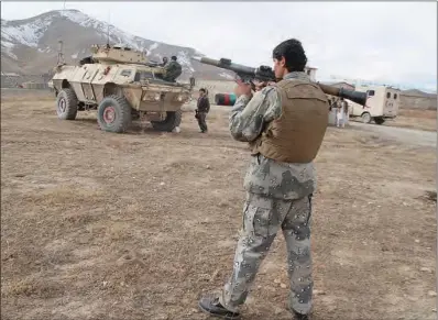  ??  ?? A security personnel holding a rocket-propelled grenade stands at a site after a suicide car bomber struck an army base on the outskirts of Ghazni province on Sunday. (AFP)