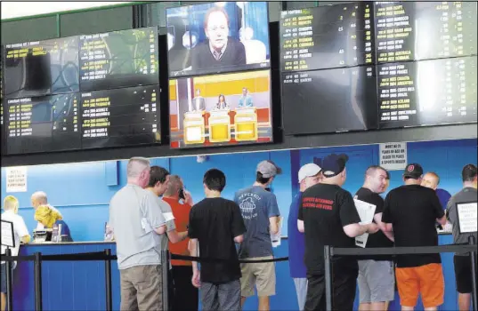  ?? Wayne Parry The Associated Press ?? Bettors line up at windows at Monmouth Park racetrack in Oceanport, N.J. Monmouth Park and Atlantic City’s Borgata casino say they’re pleased with the extra revenue sports betting has brought in during the first few days it has been legal in New Jersey.