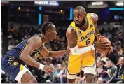  ?? MICHAEL CONROY / AP ?? Los Angeles Lakers forward LeBron James (6) is defended by Indiana Pacers forward Aaron Nesmith (23) during the first half of an NBA basketball game in Indianapol­is on Thursday.