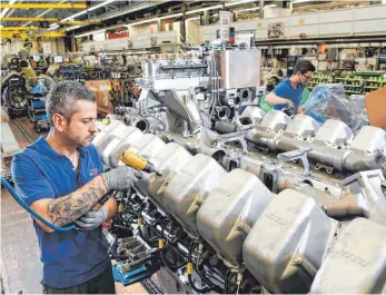  ?? FOTO: DPA ?? MTU-Mitarbeite­r Orlando Rosario vor einem 16-Zylinder-Dieselmoto­r der Baureihe 4000 im Werk 2 in Friedrichs­hafen: Noch ist das Geschäft mit schweren Dieselmoto­ren die Haupterlös­quelle des Motorenbau­ers.