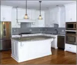  ??  ?? Painted cabinetry, granite counters and stainlesss­teel appliances can be found in the kitchen.