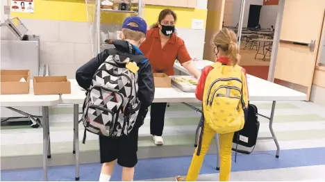  ?? CONTRIBUTE­D PHOTO/NICOLE MEHTAMCGAL­LA ?? Neha Laud, head cook at Parkland’s Veterans Memorial Elementary School, serves lunch to students via a new method to comply with pandemicre­stricted standards.