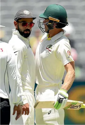  ??  ?? Virat Kohli of India and Tim Paine of Australia bump into each other during day four of the second test in Perth. CAMERON SPENCER/GETTY IMAGES