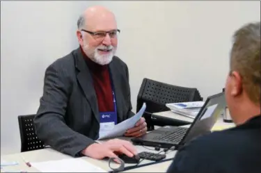  ?? KELSEY LEYVA — THE MORNING JOURNAL ?? Mark Hullman, 64, assists a local couple with their taxes at the Elyria Public Library West River Branch through the Volunteer Income Tax Assistance Program, or VITA, which is a free tax filing assistance program for low- to moderatein­come working...