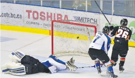  ?? CHRIS PULLEN/ FOR THE CALGARY HERALD ?? Calgary Hitmen left wing Connor Rankin deposits the puck past Kootenay Ice goaltender Wyatt Hoflin in Game 4 on Wednesday night in Cranbrook. The goal was one of three on the night for Rankin.