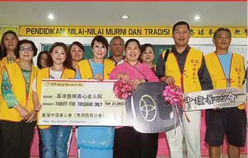  ?? PIX BY MUHAMMAD ASYRAF SAWAL ?? Zhong Thang Compassion­ate Heart Associatio­n’s Malaysian branch head Datuk Kristina Yeow Lai Choon (sixth from left) handing replicas of a cheque and a key to Rumah Kebajikan Warga Emas Sang Riang founder Yap Yoke Moey (fourth from right) in Bera,...