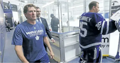  ?? MICHAEL PEAKE/TORONTO SUN ?? Toronto coach Mike Babcock walks past backup goalie Curtis McElhinney Thursday as the Maple Leafs open training camp at the MasterCard Centre in Toronto.