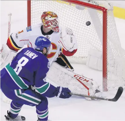  ?? BEN NELMS/THE CANADIAN PRESS ?? Vancouver Canucks defenceman Christophe­r Tanev scores the game-winning goal against Calgary Flames goaltender Brian Elliott during overtime on Saturday night in Vancouver. The NHL game was the first of six Rogers will broadcast in virtual reality this...