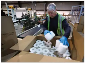  ??  ?? Scott Mitchell fills a box with toilet paper last week at the Tissue Plus factory in Bangor, Maine. The new company has been busy as consumers’ stockpilin­g has led to a shortage of toilet paper. (AP/Robert F. Bukaty)
