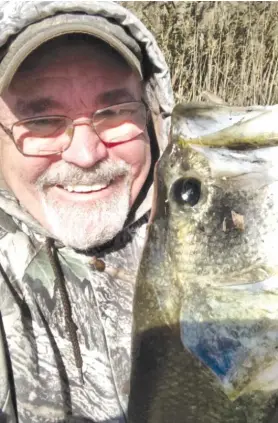  ?? DALE BOWMAN/FOR THE SUN-TIMES ?? Dale Bowman shows the joy of catching his biggest largemouth bass of the season in the final fishing days of the year at the north unit of Mazonia.