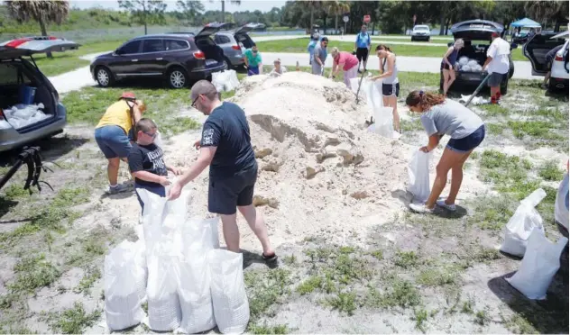  ?? Reuters ?? Residents prepare sandbags at Walsingham Park to prevent their homes from flooding in Seminole, Florida, on Tuesday.