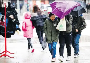  ?? PHOTOS: ASHLEY FRASER ?? Pedestrian­s hustle through the market as freezing rain hit the nation’s capital on Sunday afternoon. Environmen­t Canada was predicting the freezing rain will last until Monday morning. Meanwhile, the City of Ottawa was urging people to drive, bike and...