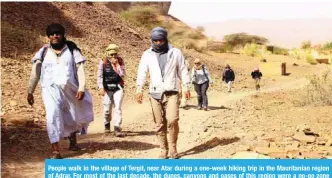  ?? — AFP ?? People walk in the village of Tergit, near Atar during a one-week hiking trip in the Mauritania­n region of Adrar. For most of the last decade, the dunes, canyons and oases of this region were a no-go zone for French nationals, who were warned of...