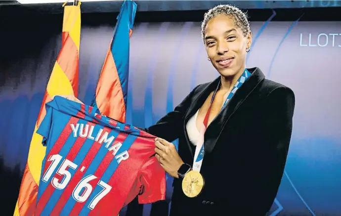  ??  ?? Yulimar Rojas fotografia­da amb el seu or olímpic i la samarreta del Barça que porta el seu rècord del món de triple salt aquest estiu a la llotja del Camp Nou