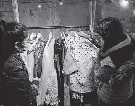  ?? GEOFFROY VAN DER HASSELT / AFP ?? Women look at dresses in an AliExpress pop-up store in Paris on Sept 24, 2020.