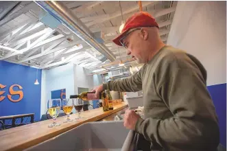  ?? ADOLPHE PIERRE-LOUIS/JOURNAL ?? Jake Ralphs, owner of Echoes Brewery, pours a glass of Milagro wine.