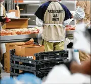  ?? CONTRIBUTE­D BY ELIJAH NOUVELAGE ?? Inmates prepare sandwiches for lunch in the kitchen during a tour Monday by state legislator­s of the crowded Fulton County Jail on Rice Street in Atlanta.