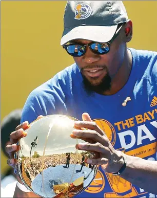  ?? KARL MONDON/TRIBUNE NEWS SERVICE ?? Kevin Durant clutches the Larry O' Brien Trophy at the Golden State Warriors' NBA championsh­ip rally on June 15 in Oakland.