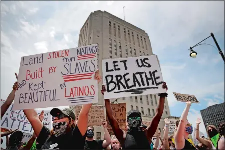  ?? CHARLIE RIEDEL/AP PHOTO ?? People hold signs during a rally Friday in downtown Kansas City, Mo., to protest the death of George Floyd, who died after being restrained by Minneapoli­s police officers on May 25.