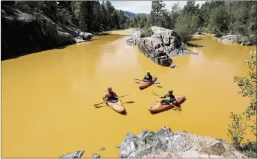  ?? JERRY MCBRIDE — THE DURANGO HERALD VIA AP ARCHIVES ?? People kayak in water colored from a mine waste spill near Durango, Colo. In 2015, an estimated 3million gallons of wastewater poured out, carrying nearly 540U.S. tons of metals, mostly iron and aluminum.