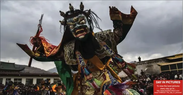  ?? Picture: Kevin Frayer/getty ?? „ A Tibetan Buddhist Monk of the Yellow Hat school wears a mask as he dances a Cham dance at the Rongwo monastery during Monlam or the Great Prayer, in Tongren in the Tibetan Autonomous Prefecture in China. Monlam is the most important prayer event for...