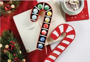  ??  ?? Norman Love Confection­s has also created a special, limited- edition candy cane-shaped gift box that includes 10 chocolates from the holiday collection.