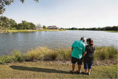  ??  ?? Mike and Linda Baker look over the lake at Mission Ranch in College Station, where the couple is building a home.