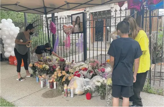  ?? MANNY RAMOS/SUN-TIMES ?? A vigil for 10-year-old Lena Nunez is held outside her Logan Square apartment Monday evening.