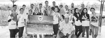  ??  ?? Wid (seated centre) and Nadine (first row, sixth left) with the participan­ts of the beach clean-up.