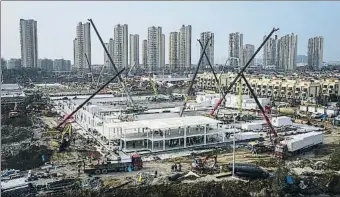  ?? GETTY IMAGES ?? Obres a tota
màquina. Ahir, tres dies després que comencessi­n les obres, el nou hospital de Wuhan, que ha d’entrar en servei la setmana que ve, ja tenia dos pisos