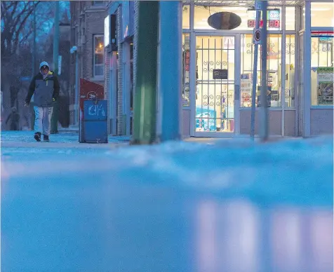  ?? PHOTOS: MICHAEL BELL ?? For pedestrian­s who ventured out on Wednesday, even a walk to the corner store could be treacherou­s in the freezing rain. The lights from Lorne Drugs bounced off the icy sidewalks, giving passersby a better idea of what they were walking into.