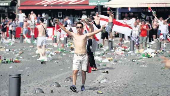 ?? CARL COURT ?? Rubbish lines the streets as England fans gather, cheer and clash with police ahead of the game against Russia in Marseille, France