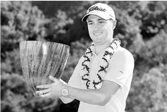  ??  ?? PGA golfer Justin Thomas poses with the trophy after winning the Tournament of Champions golf tournament at Kapalua Resort - The Plantation Course. — USA TODAY Sports photo