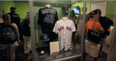  ?? MIKE GROLL — THE ASSOCIATED PRESS FILE ?? In this file photo, fans visit a Pedro Martinez exhibit at the Baseball Hall of Fame in Cooperstow­n, N.Y. This weekend, brings the latest crop of inductees into the Baseball Hall of Fame, the ultimate repository of the game’s yesterdays, Vladimir Guerrero, Chipper Jones, Jack Morris, Alan Trammell, Jim Thome and Trevor Hoffman. Modern players who now belong to the ages.