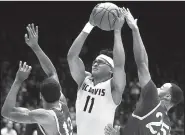  ?? AP/JOHN MINCHILLO ?? UC Davis forward Chima Moneke (center) pulls down a rebound between North Carolina Central defenders Pablo Rivas (left) and Kyle Benton during the second half of an NCAA Tournament First Four game Wednesday in Dayton, Ohio. Moneke finished with 18...