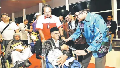 ??  ?? JAGA DIRI: Abang Johari mengucapka­n selamat jalan kepada jemaah haji Sarawak yang berlepas ke Mekah dari LTAK di Kuching, malam kelmarin.