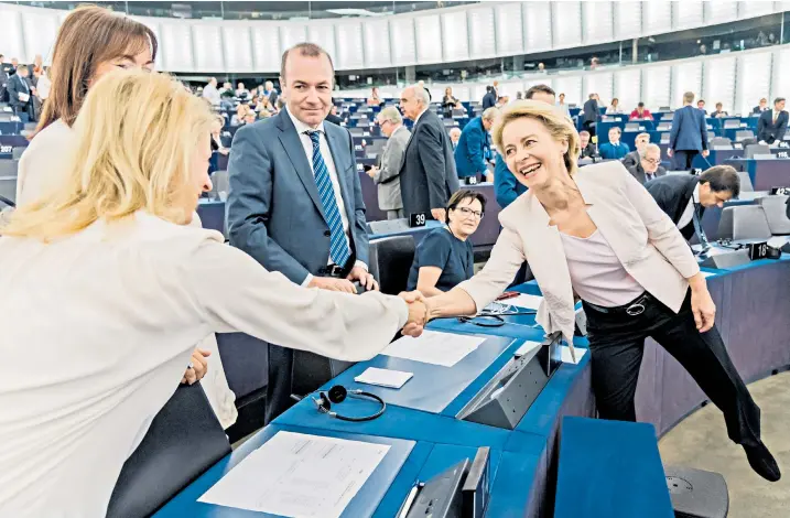  ??  ?? Ursula von der Leyen, the new president of the European Commission, right, shakes hands with an MEP, beside Manfred Weber, chairman of the European People’s Party (EPP), centre, at the European Parliament in Strasbourg yesterday