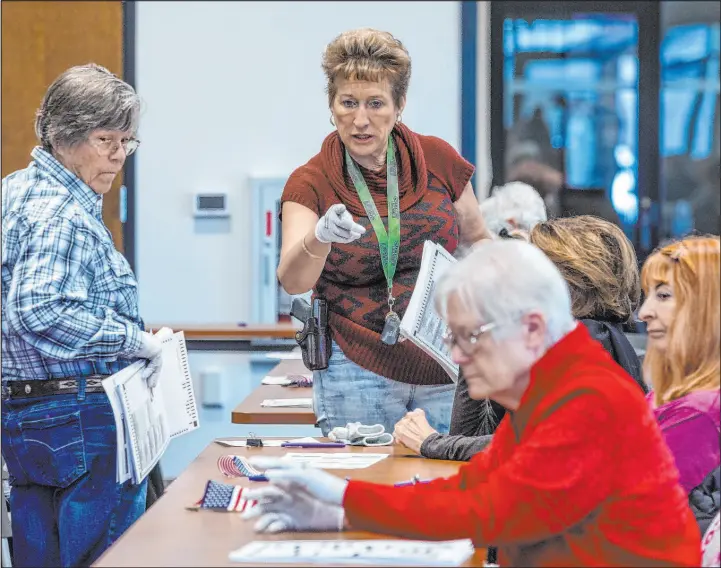  ?? Las Vegas Review-journal @Left_eye_image ?? L.E. Baskow
A supervisor makes a clarificat­ion as volunteers hand-count Nye County ballots on Thursday in at the Valley Conference Center in Pahrump.