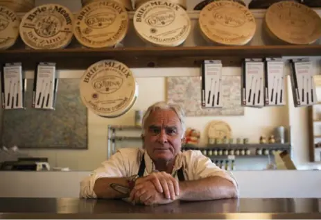  ?? MELISSA RENWICK/TORONTO STAR ?? Robert Burns, owner of La Fromagerie, says his 12-year-old cheese shop is "treading water" because of a College St. beautifica­tion project.