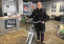  ?? CORNELIUS FROLIK / STAFF ?? Laura Estandia, executive director of Bike Miami Valley, shows off one of Link Dayton Bike Share’s new electric bikes. eLink, the new electric-assisted bikes, will debut this spring.