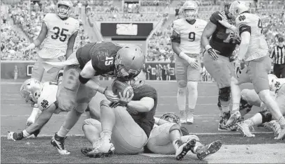  ?? Sam Greenwood Getty Images ?? NAVY QUARTERBAC­K Will Worth (15) runs for one of his two touchdowns in Midshipmen’s 28-27 win over Notre Dame.