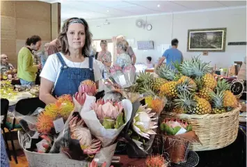  ?? Pictures: FAITH QINGA ?? NATURE’S BEAUTIFUL BOUNTY: Elaine Thompson sells proteas and pineapples for Settlers Park’s social committee at the morning craft market